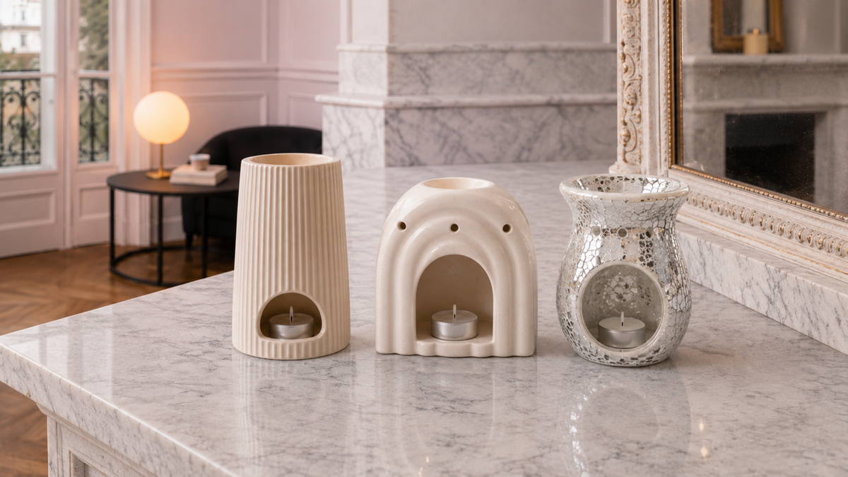 Collection de 3 brûle-parfums de la marque Blondie Boujee posés sur une cheminée en marbre blanc